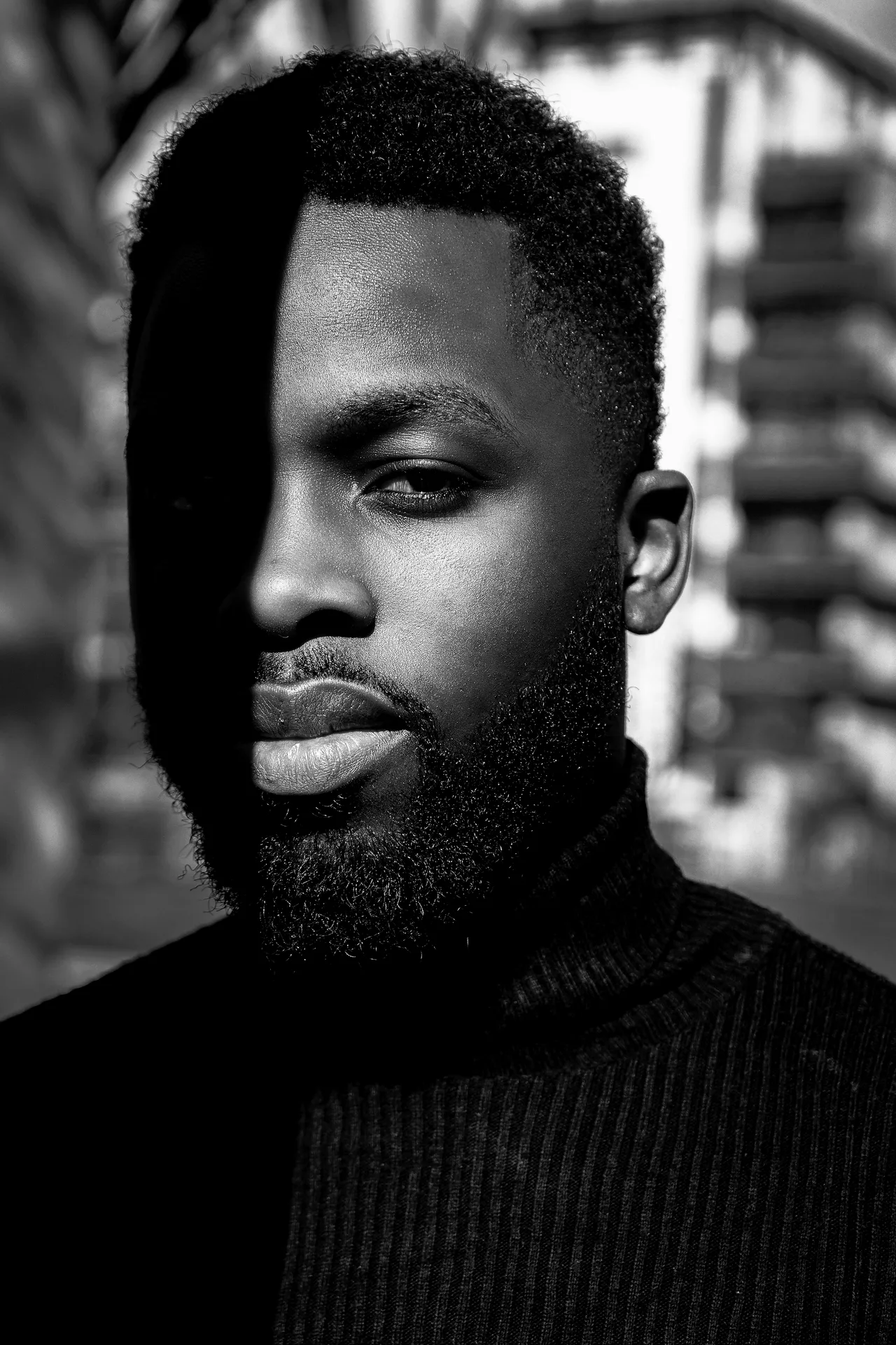 Portrait of Jaylen Brooks in a black turtleneck, half his face in shadow